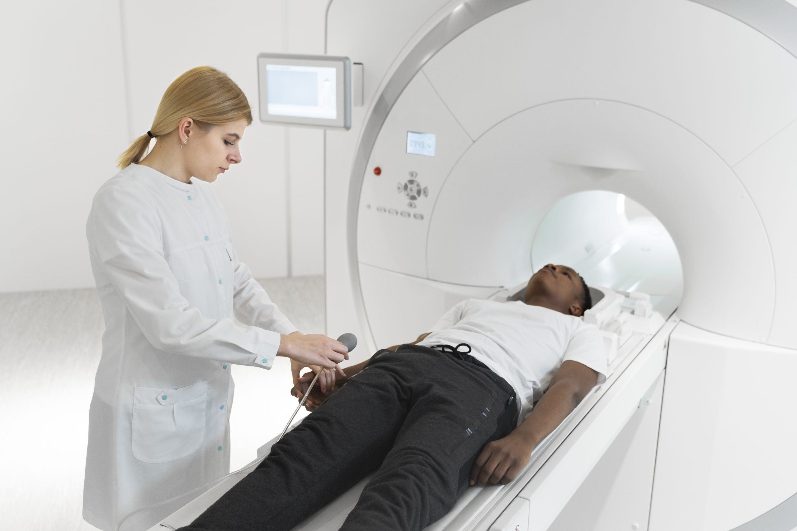 Hospital technician preparing patient for MRI diagnostic scan